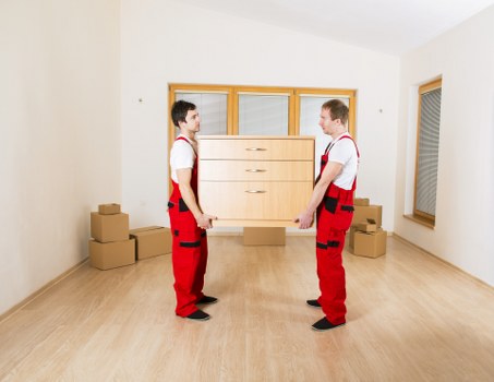 Staff member wearing PPE while carrying boxes on a removal job